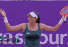 a woman holding a tennis racquet in front of a purple sign that says burg