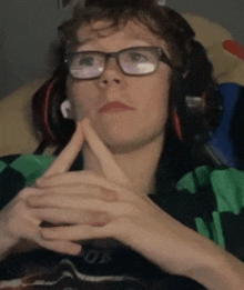 a man wearing glasses and headphones is making a peace sign with his hands