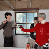a man in a red sweater with the number 1 on it is holding a toy gun