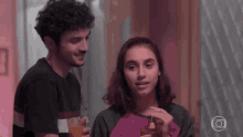 a man and a woman are sitting next to each other in a room .