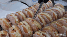 a bunch of donuts are on a table and the words made in animotica are on the bottom right