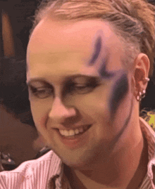 a man with purple paint on his face smiling