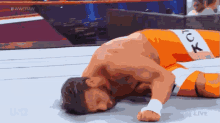 a wrestler is laying on the ground in a wrestling ring with the words #wweraw visible in the background