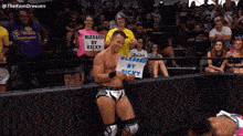 a wrestler holds up a sign that says blessed by ricky