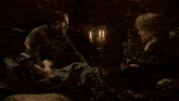 a group of people are sitting on the floor in a dark room with candles