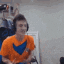 a man wearing headphones is sitting in a chair and playing a video game .