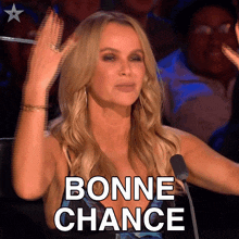 a woman sitting in front of a microphone with the word bonne chance written on her face