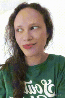 a woman wearing a green shirt that says ' two ' on it