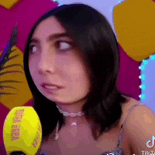 a woman is talking into a yellow microphone that says mega feria on it .