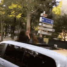a woman in a car is looking out the window at a street sign that says toulouse on it