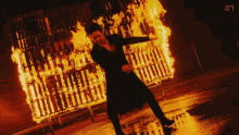 a man is standing in front of a burning building