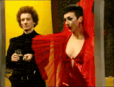 a man and a woman are standing next to each other and the woman is wearing a red dress