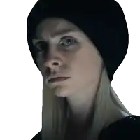 a woman wearing a black beanie looks at the camera