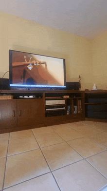 a flat screen tv is on a wooden entertainment center