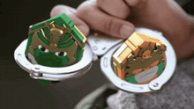 a person is holding a pair of handcuffs with a ninja turtle face on them