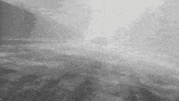 a car is driving down a foggy road .