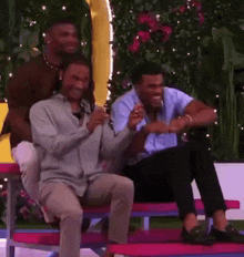a group of men are sitting on a bench laughing and talking .