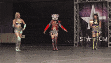 three women are standing in front of a sign that says stardom