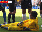 a soccer player with the number 4 on his shorts is laying on the grass