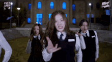 a group of girls are dancing in front of a building that has jtbk written on it