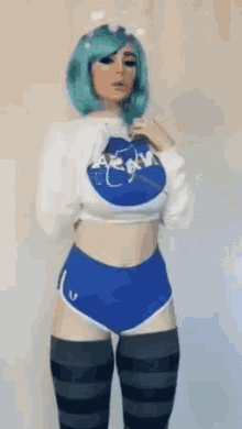 a woman with green hair and blue shorts is wearing a nasa shirt and shorts .
