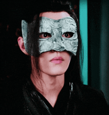 a man with long hair is wearing a mask that looks like a cat