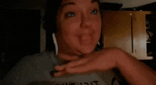a woman is sticking her tongue out while wearing headphones and making a funny face .