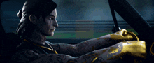 a man with a tattoo on his arm is driving a car at night