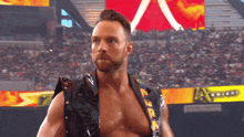 a wrestler is standing in front of a crowd with a sign that says arizona on it
