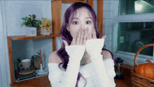 a woman with purple hair covering her face with her hands