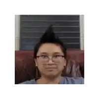 a woman wearing glasses and a mohawk looks at the camera