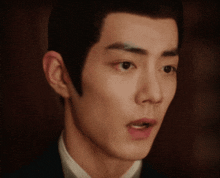a close up of a young man 's face with a surprised look on his face