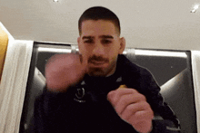 a man with a beard is making a fist in the air