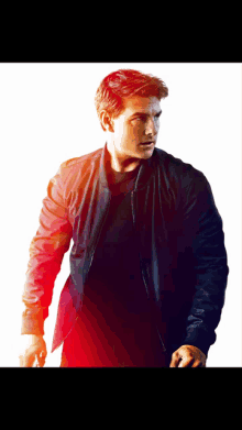 a man in a black jacket stands in front of a white backdrop