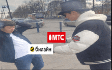 a man in a top hat stands next to a man in a white jacket with the word mtc on it