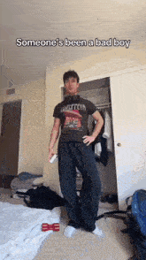 a man wearing a led zeppelin t-shirt is standing in a room .