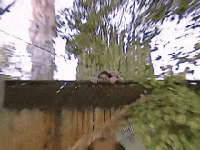 a blurry picture of a person behind a wooden fence