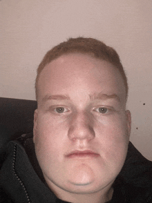 a close up of a man 's face with a black jacket on