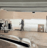a man is standing in a garage with a tiktok sticker