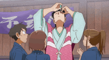 a group of people are standing around a man in a kimono with chinese writing on a banner behind him