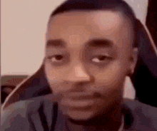 a close up of a man 's face with a serious look on his face while sitting in a chair .