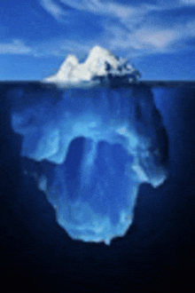 a large iceberg is floating on top of a body of water in the ocean .