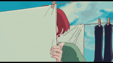 a woman with red hair is covering her face behind a piece of cloth