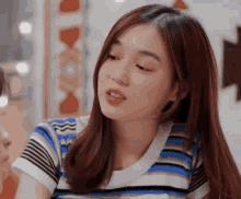 a close up of a woman wearing a striped shirt .