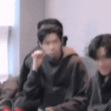 a blurry picture of a man sitting on a couch eating a sandwich .