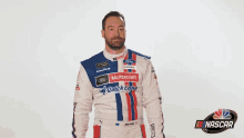 a man in a racing suit is standing in front of a white background and saying sorry .