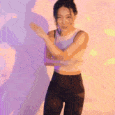 a woman in a white top and black pants is dancing