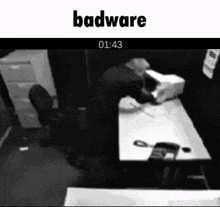 a black and white photo of a man sitting at a desk with the words badware at the bottom