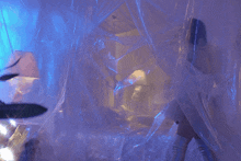 a woman in a white dress is standing in a room with a blue light behind her