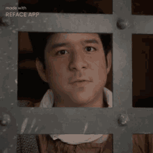 a man in a prison cell is looking through a window made with the reface app